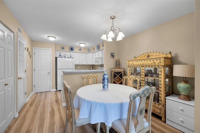 dining room featuring light hardwood / wood-style floors and a notable chandelier