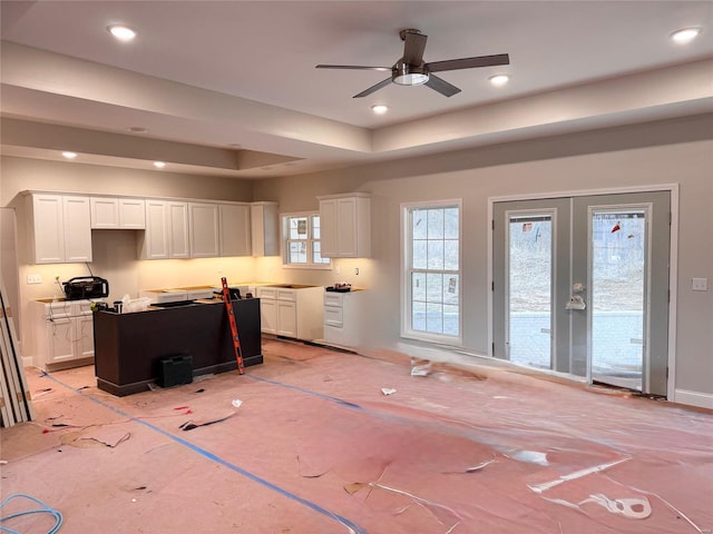 office space with french doors, ceiling fan, and a tray ceiling