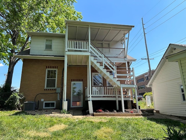 rear view of property featuring central AC and a yard