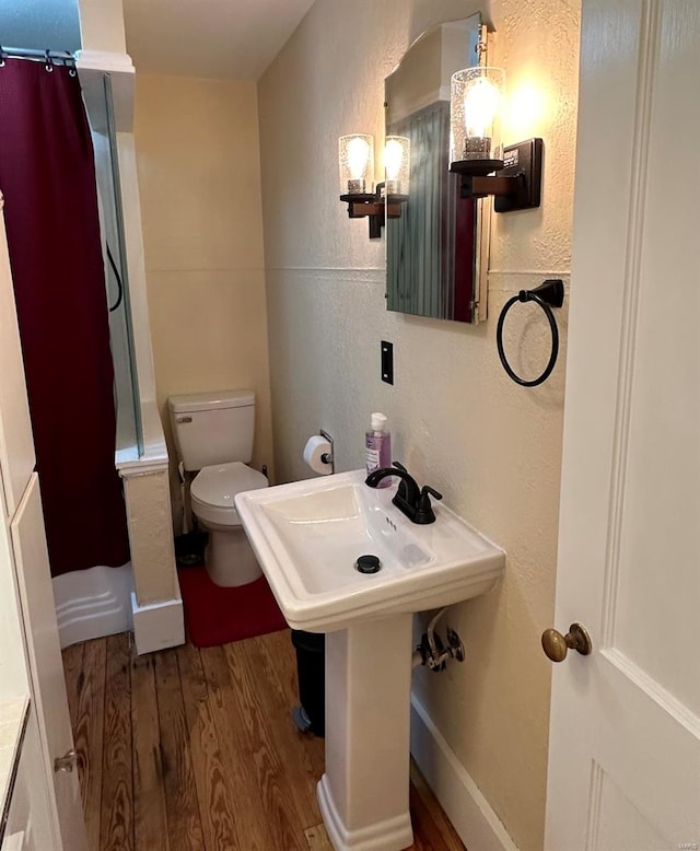 bathroom with toilet and hardwood / wood-style flooring