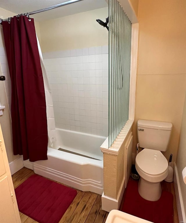 bathroom with hardwood / wood-style floors, shower / tub combo, and toilet