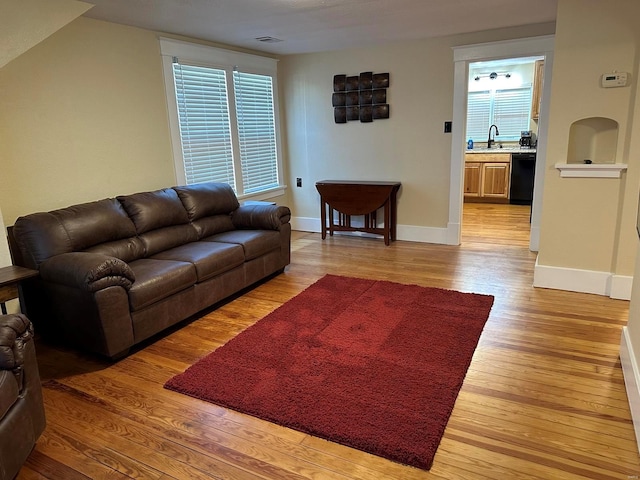 living room with light wood-type flooring and sink