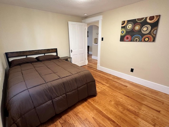 bedroom with a textured ceiling and light wood-type flooring