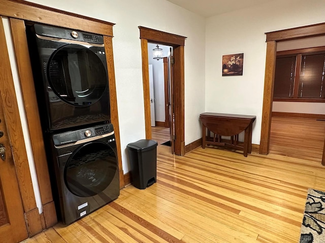 washroom with light wood-type flooring and stacked washer and clothes dryer