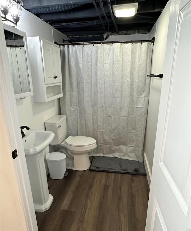 bathroom with walk in shower, wood-type flooring, and toilet