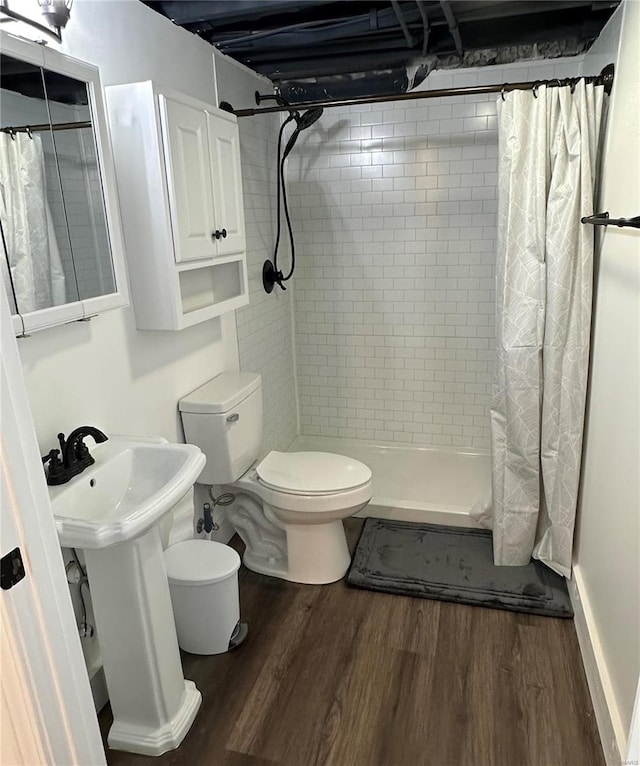 bathroom with hardwood / wood-style floors, toilet, curtained shower, and sink