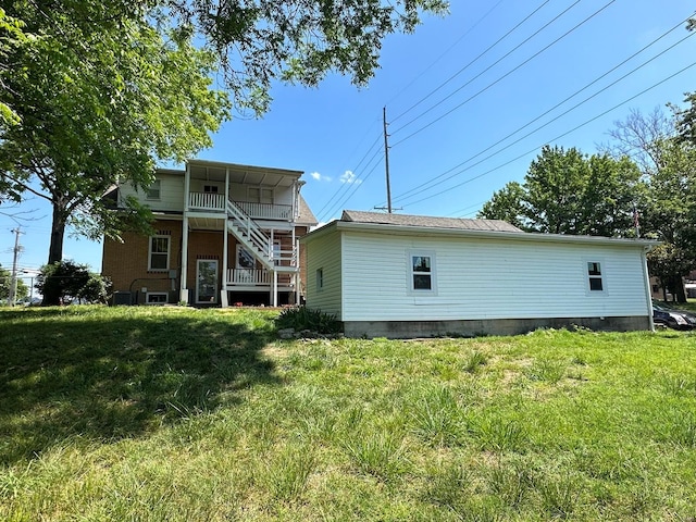 rear view of property featuring a lawn