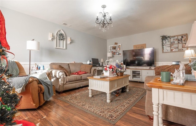 living room with dark wood-type flooring and a chandelier