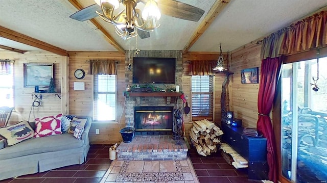 tiled living room with beamed ceiling, a fireplace, wood walls, and a textured ceiling