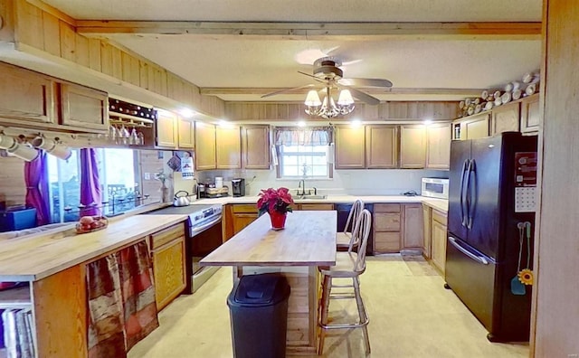 kitchen with a kitchen island, black fridge, stainless steel range with electric cooktop, and butcher block counters