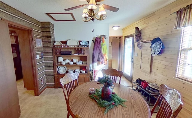 dining area featuring a textured ceiling, a wealth of natural light, and wood walls