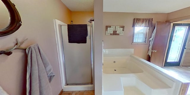 bathroom featuring a textured ceiling and independent shower and bath