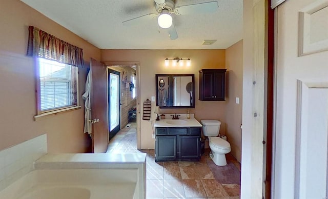 bathroom featuring ceiling fan, vanity, a textured ceiling, and toilet