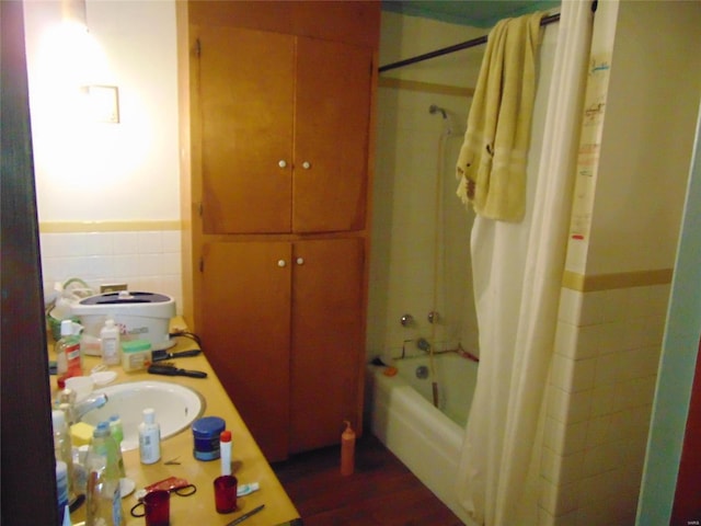 bathroom featuring tile walls, sink, shower / bath combo, and hardwood / wood-style flooring