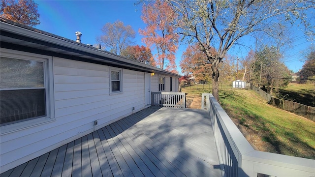 wooden terrace with a lawn and a shed