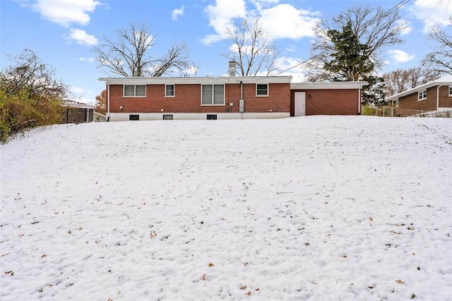 view of snow covered back of property