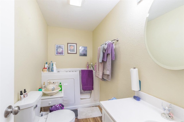 bathroom featuring wood-type flooring, vanity, and toilet