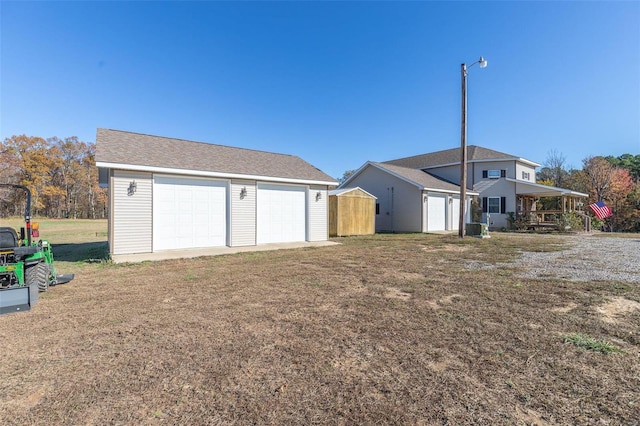 rear view of property with an outdoor structure and a garage