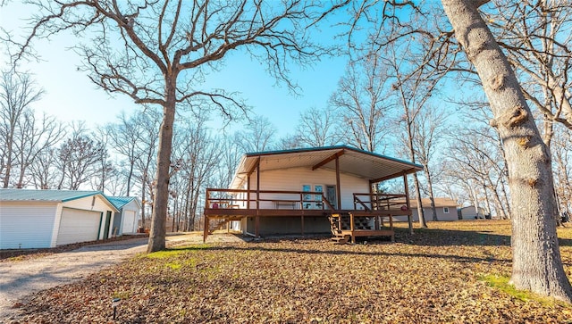 exterior space with an outbuilding, a garage, and a deck