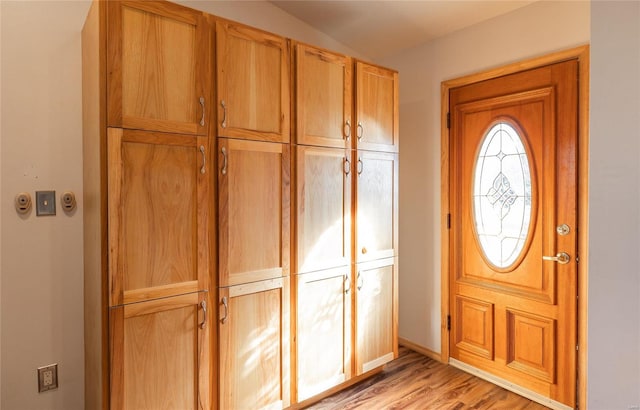 entryway with light hardwood / wood-style floors and lofted ceiling