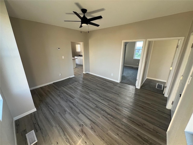 unfurnished living room featuring ceiling fan and dark hardwood / wood-style flooring