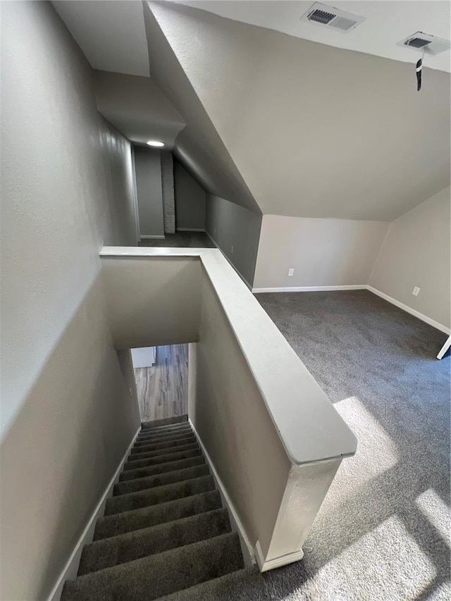 staircase with carpet floors and vaulted ceiling