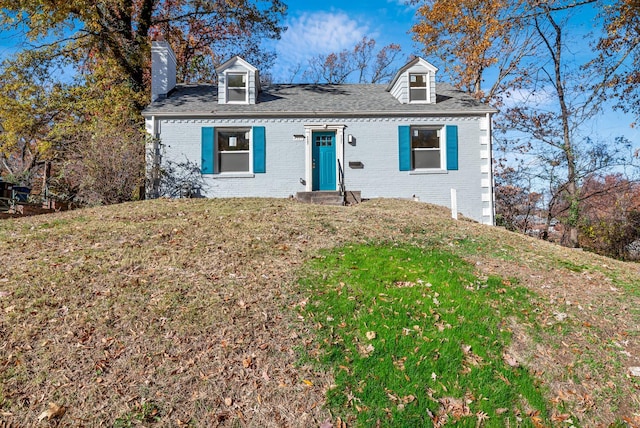 cape cod-style house featuring a front lawn