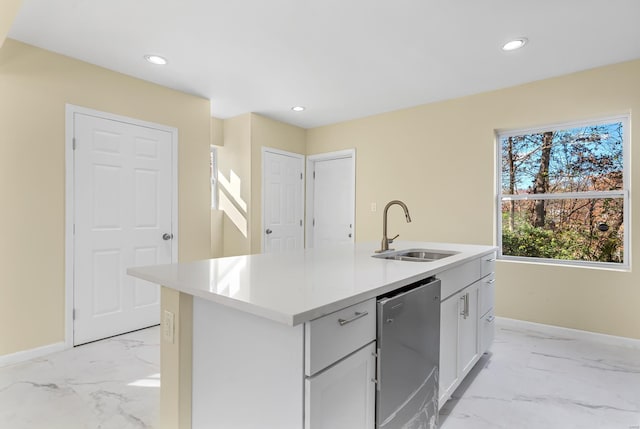 kitchen with stainless steel dishwasher, sink, and an island with sink