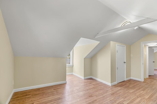 additional living space featuring light hardwood / wood-style floors and lofted ceiling