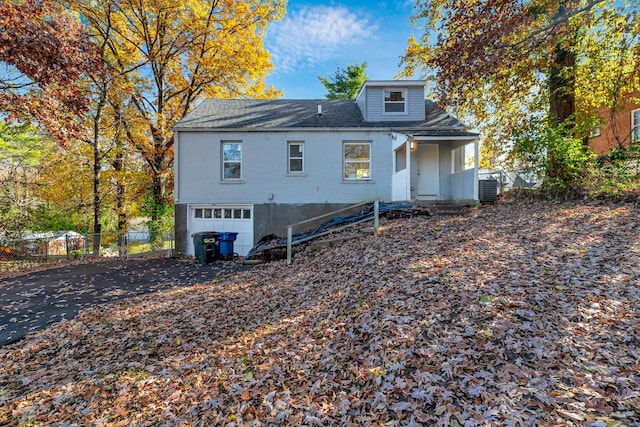 rear view of house with cooling unit and a garage