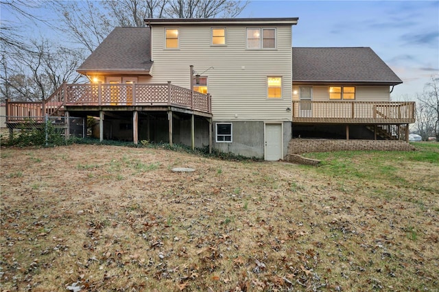 rear view of property featuring a yard and a wooden deck