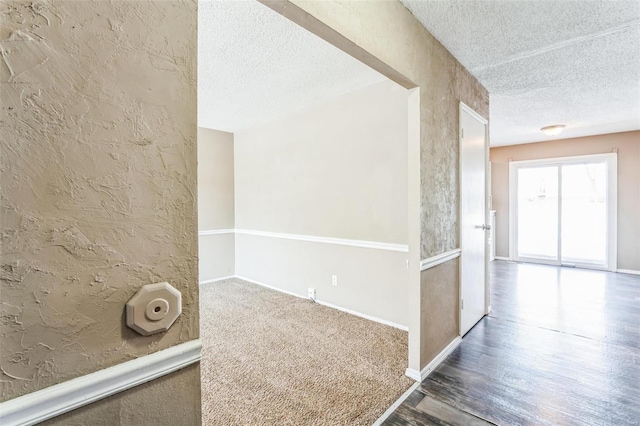 hall featuring wood-type flooring and a textured ceiling