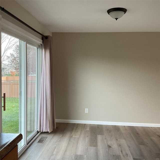 spare room featuring a wealth of natural light and light wood-type flooring