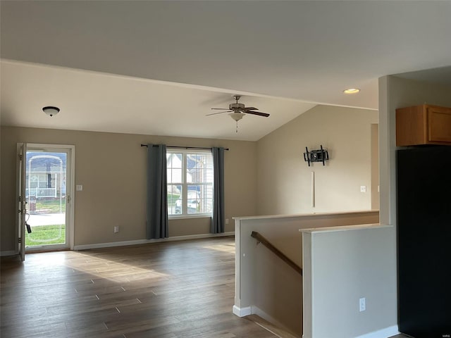 empty room featuring ceiling fan, plenty of natural light, hardwood / wood-style floors, and vaulted ceiling