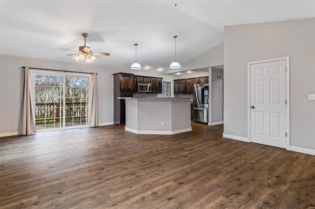 kitchen with dark brown cabinets, dark wood-type flooring, stainless steel appliances, and vaulted ceiling