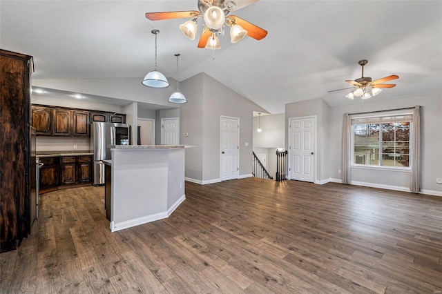 kitchen featuring lofted ceiling, stainless steel fridge, dark brown cabinetry, and dark wood-type flooring