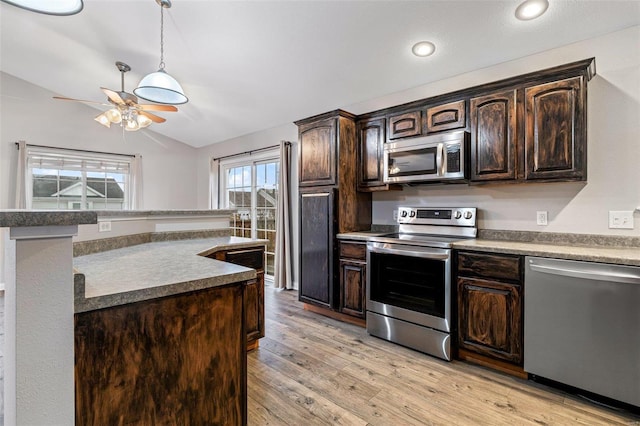 kitchen with dark brown cabinets, lofted ceiling, stainless steel appliances, and light hardwood / wood-style flooring