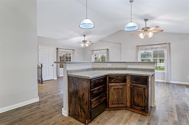 kitchen with a center island, wood-type flooring, lofted ceiling, and dark brown cabinetry