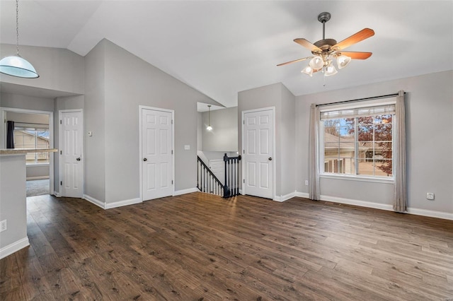 unfurnished living room with ceiling fan, high vaulted ceiling, and dark wood-type flooring