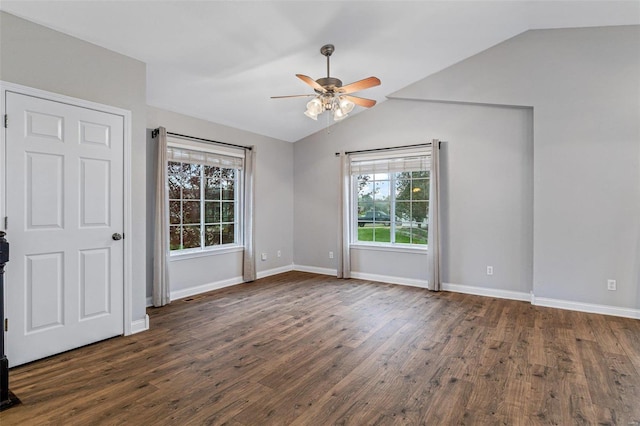 empty room featuring dark hardwood / wood-style floors, a healthy amount of sunlight, lofted ceiling, and ceiling fan