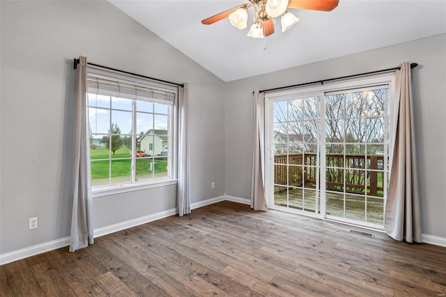 unfurnished room featuring a wealth of natural light, ceiling fan, wood-type flooring, and lofted ceiling