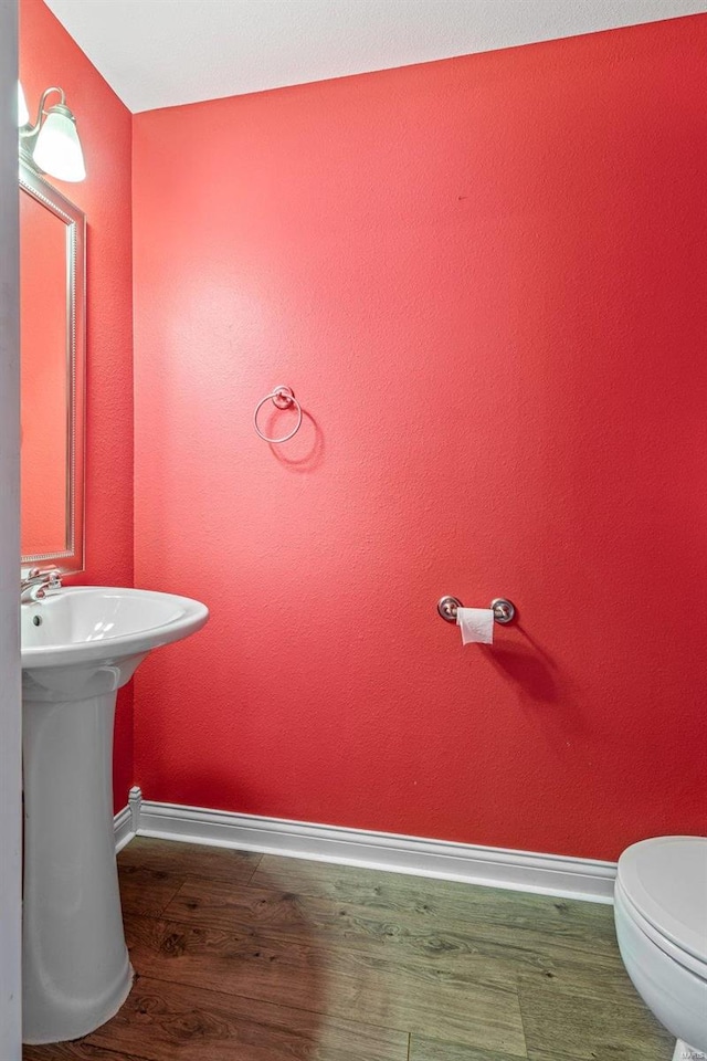 bathroom with toilet and wood-type flooring