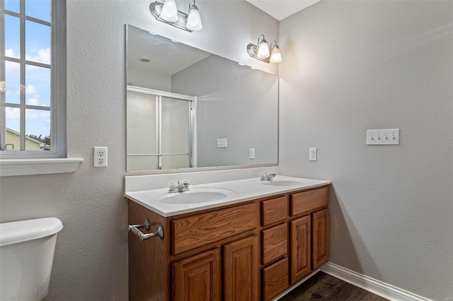 bathroom featuring hardwood / wood-style floors, vanity, toilet, and an enclosed shower