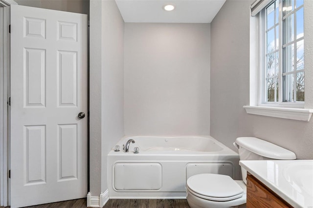 bathroom featuring vanity, toilet, wood-type flooring, and a washtub