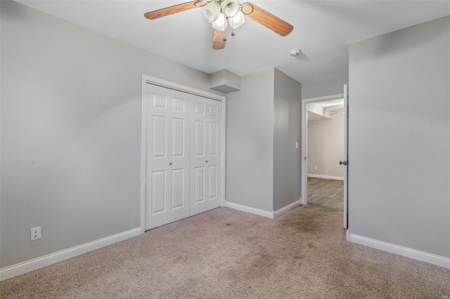 unfurnished bedroom featuring ceiling fan, light colored carpet, and a closet