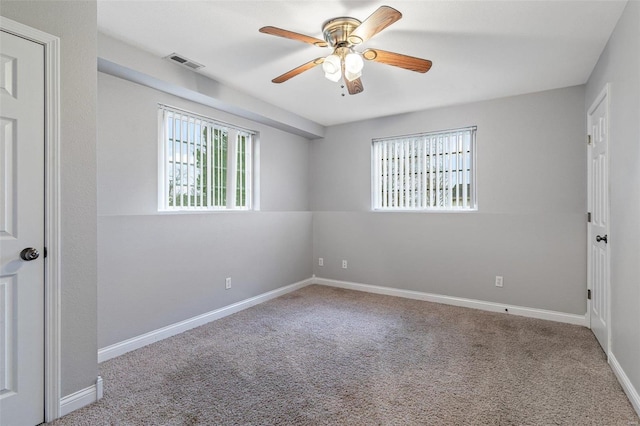 carpeted spare room with ceiling fan