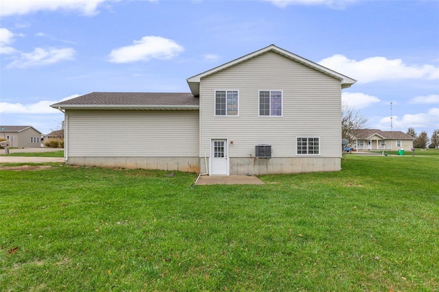 rear view of property with a lawn and central air condition unit