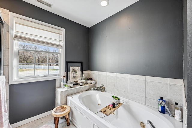 bathroom with a tub to relax in and tile patterned flooring