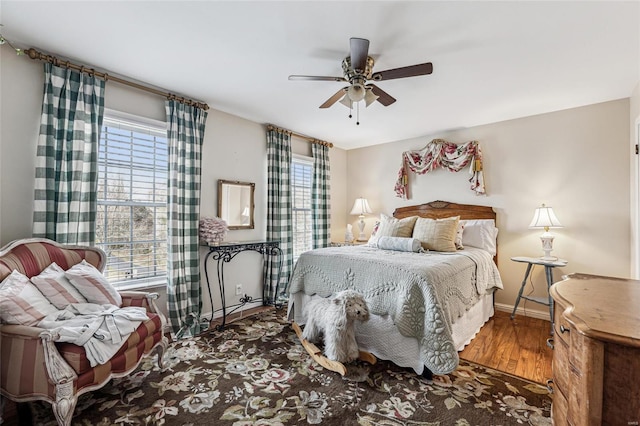 bedroom with hardwood / wood-style flooring, multiple windows, and ceiling fan