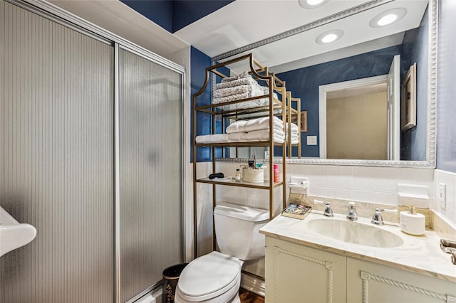 bathroom with vanity, a shower with shower door, and toilet